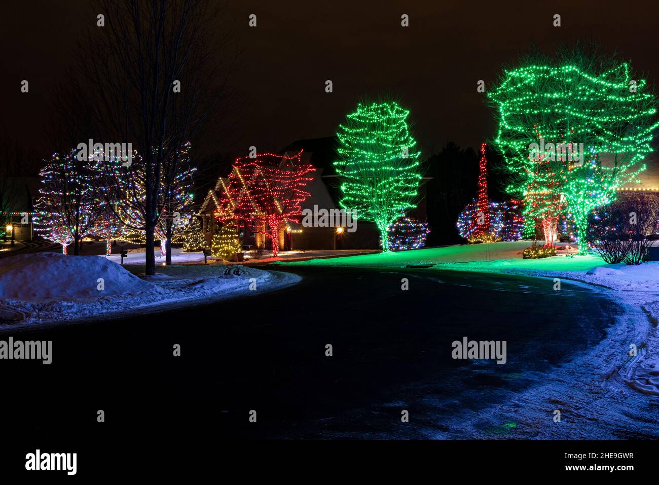 colorful holiday lights illuminate residential neighborhood Stock Photo