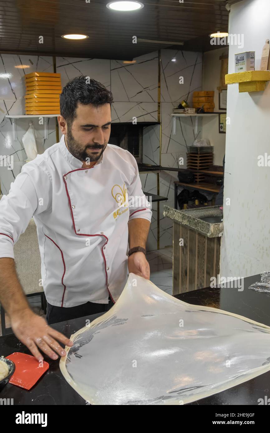 Turkish chef prepearing dough for the traditional Gaziantep flaky dessert Katmer with pistachio powder, Turkey Stock Photo