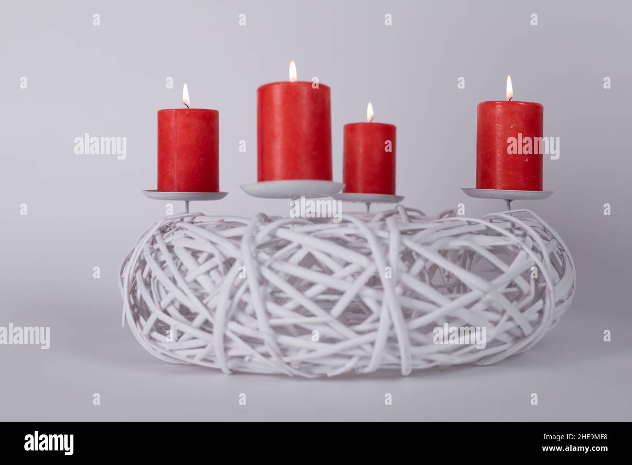 Abstract white candle stand and four red candles light up for Christmas