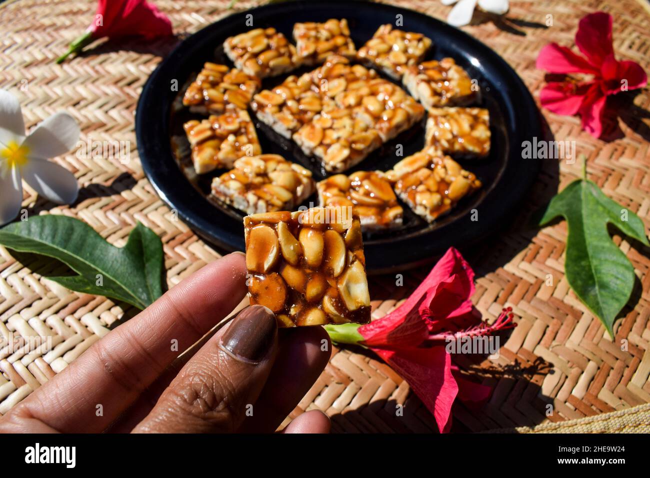 Female holding serving eating Peanut candy bars traditional Indian