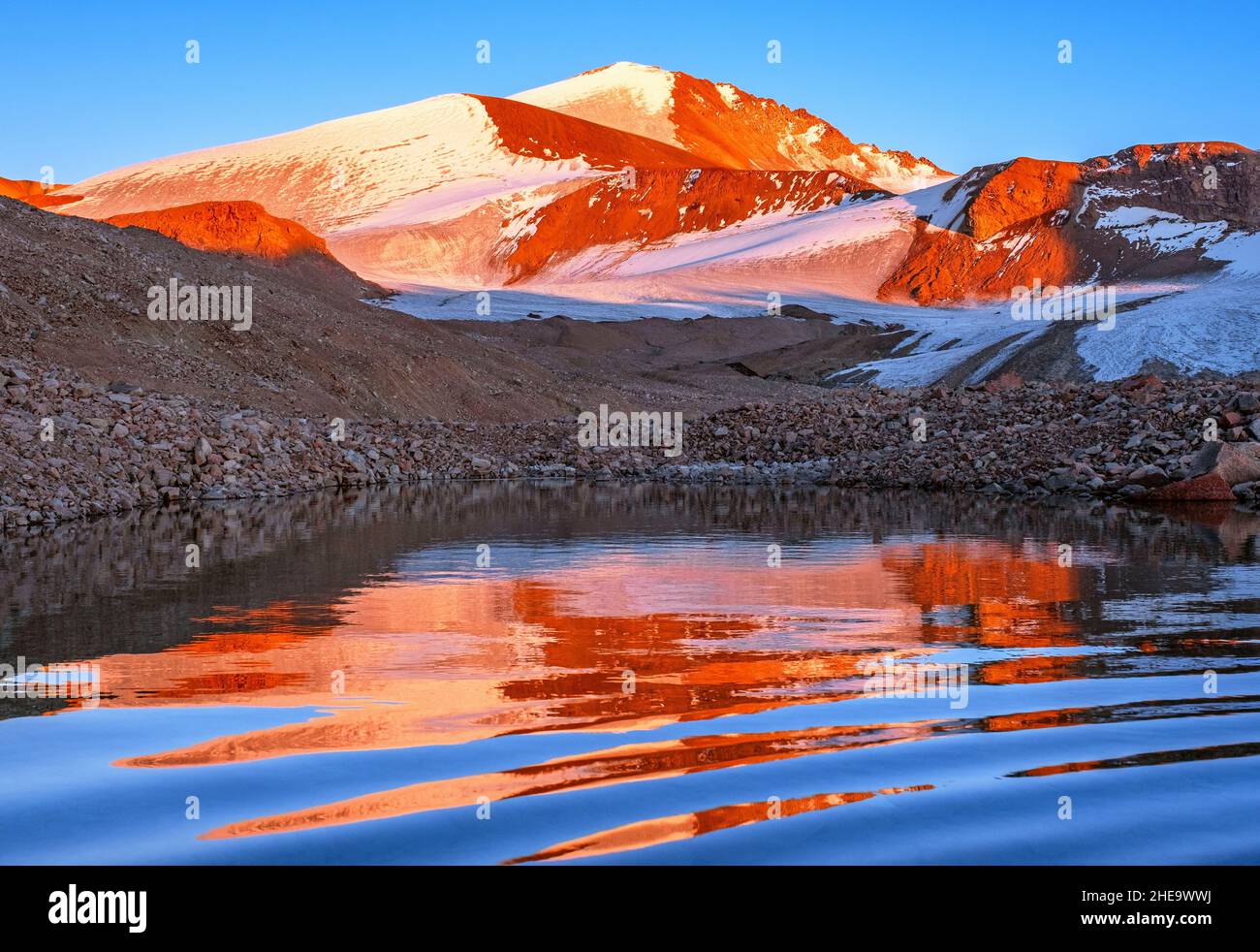 Wonderful mountain landscape; magical reflection of a mountain peak with glaciers in a moraine lake at sunset Stock Photo