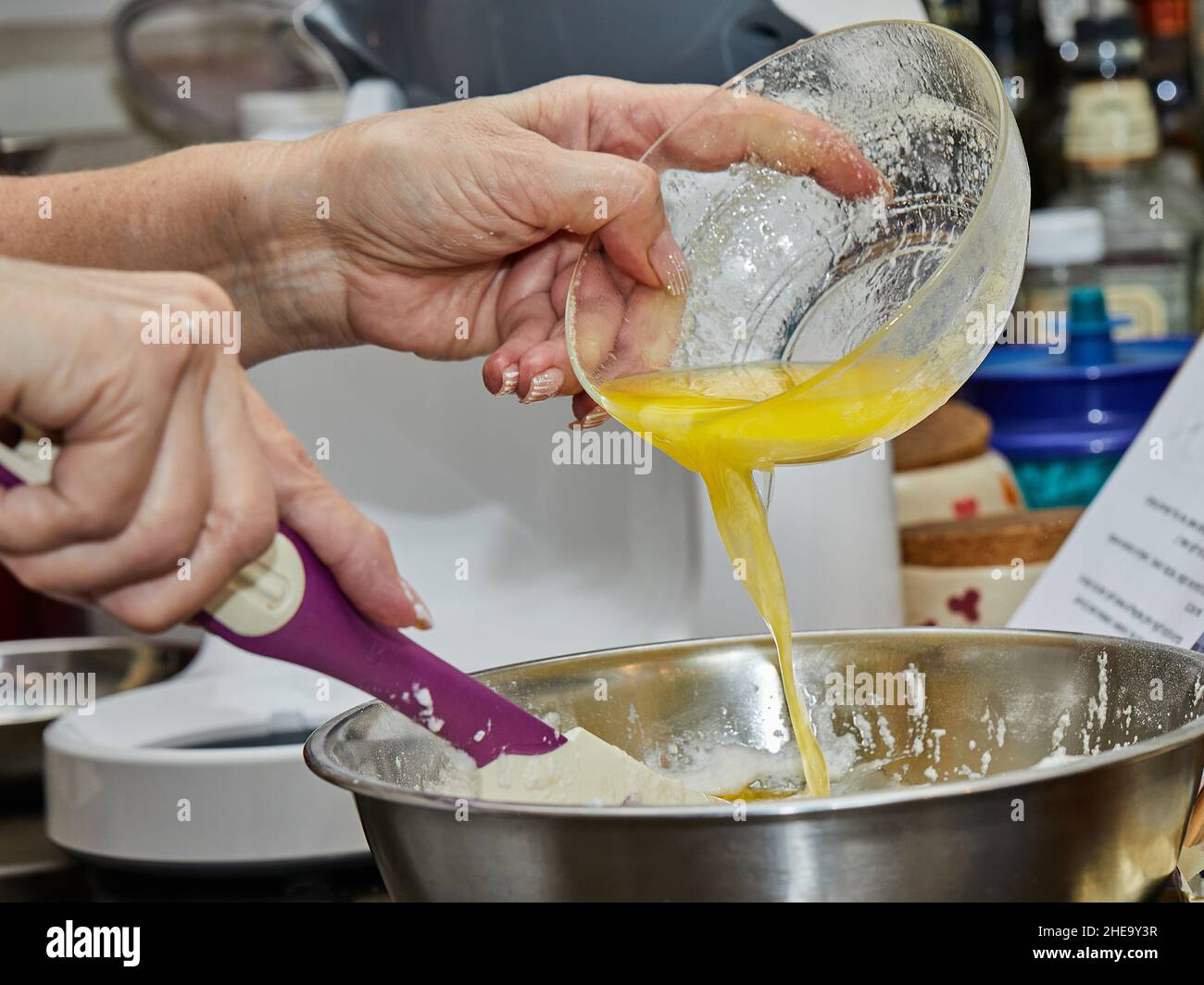 Cook puts the egg yolks in the pie bowl Stock Photo