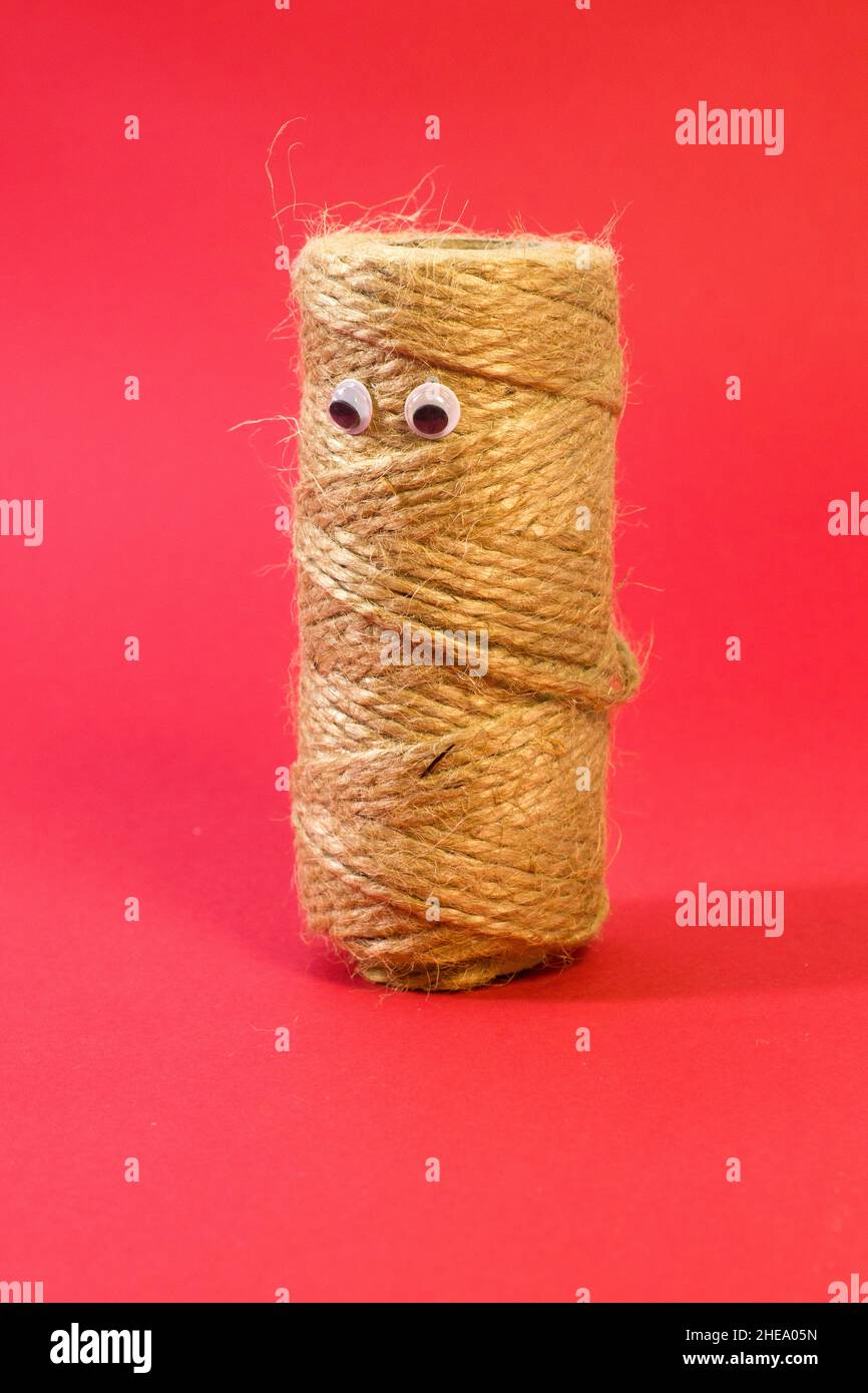 Skein of jute twine with funny eyes. Natural jute twine, macro shot. Jute thread texture on