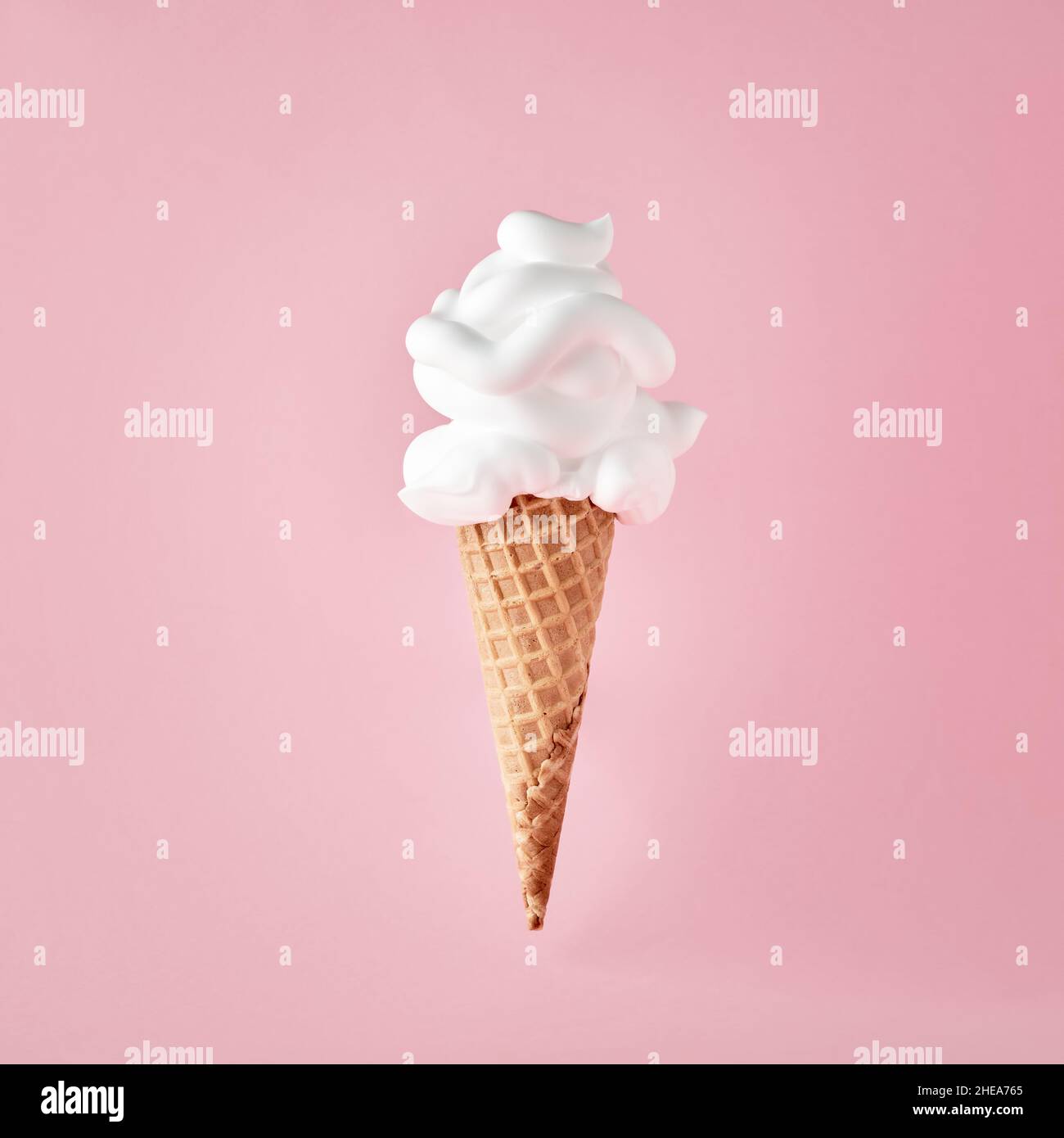 Ice cream cone with shaving foam on pink background. April Fool's Day minimalistic creative concept. Stock Photo