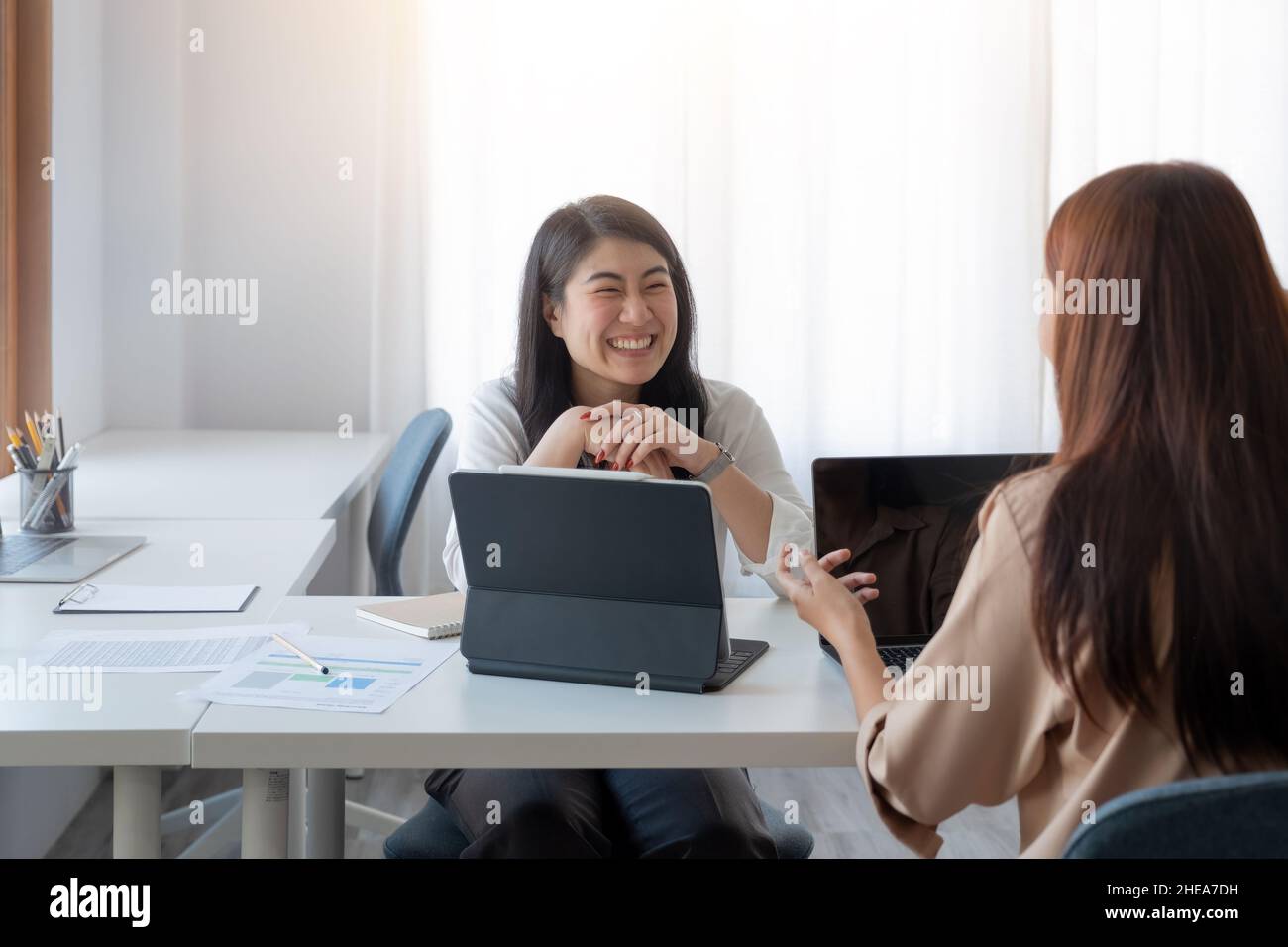 Happy asian businesswoman putting forward his suggestions to colleagues. Startup business team on meeting in modern bright office Stock Photo