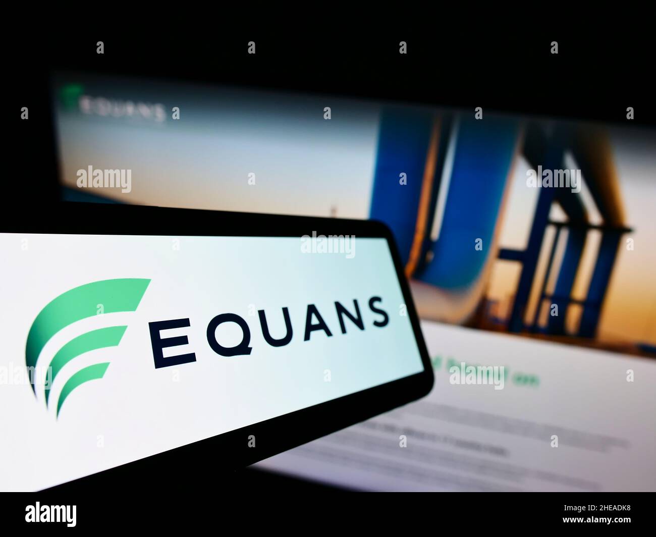 Mobile phone with logo of French facility management company EQUANS on screen in front of business website. Focus on left of phone display. Stock Photo