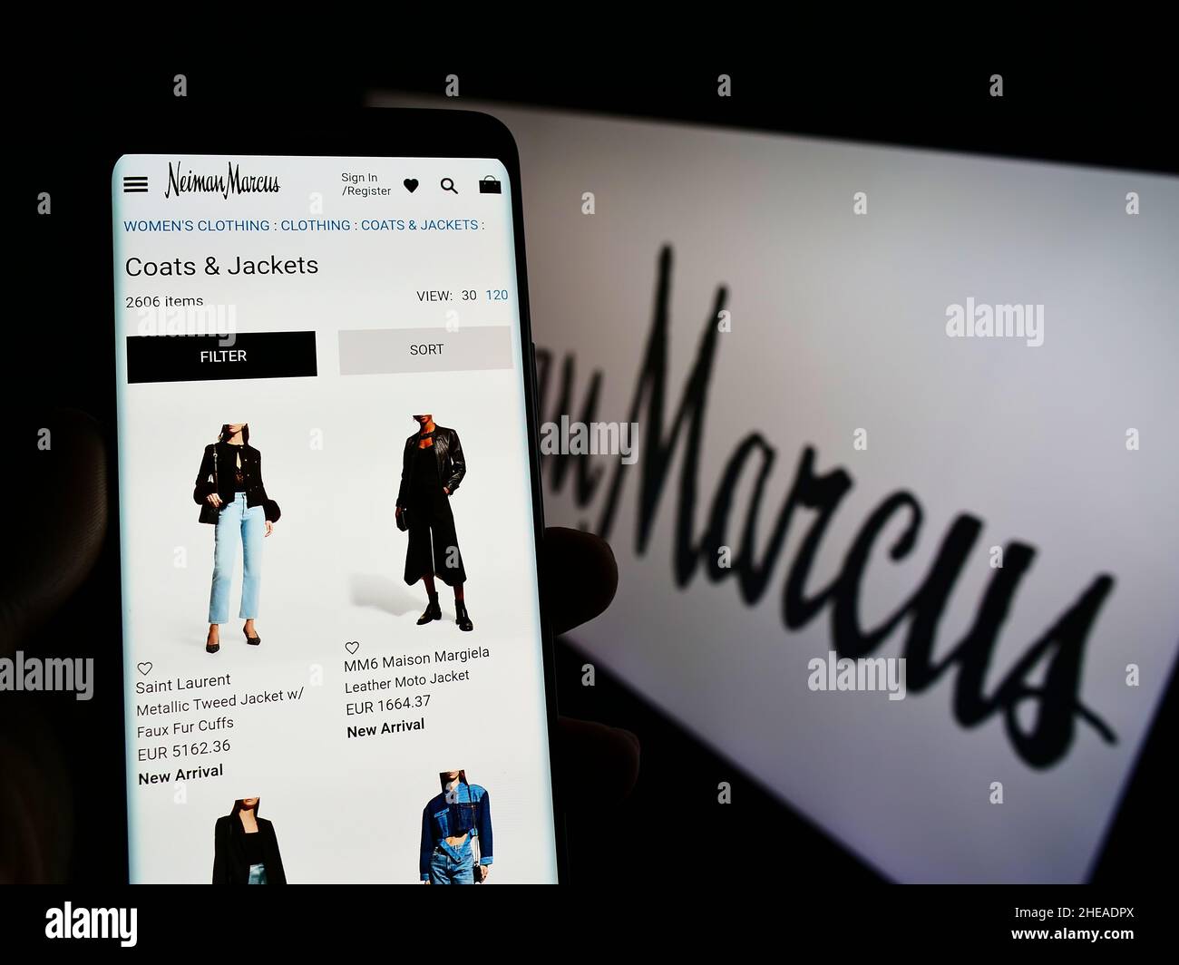 Person holding cellphone with website of US luxury retailer Neiman Marcus  Group Inc. on screen in front of logo. Focus on center of phone display  Stock Photo - Alamy