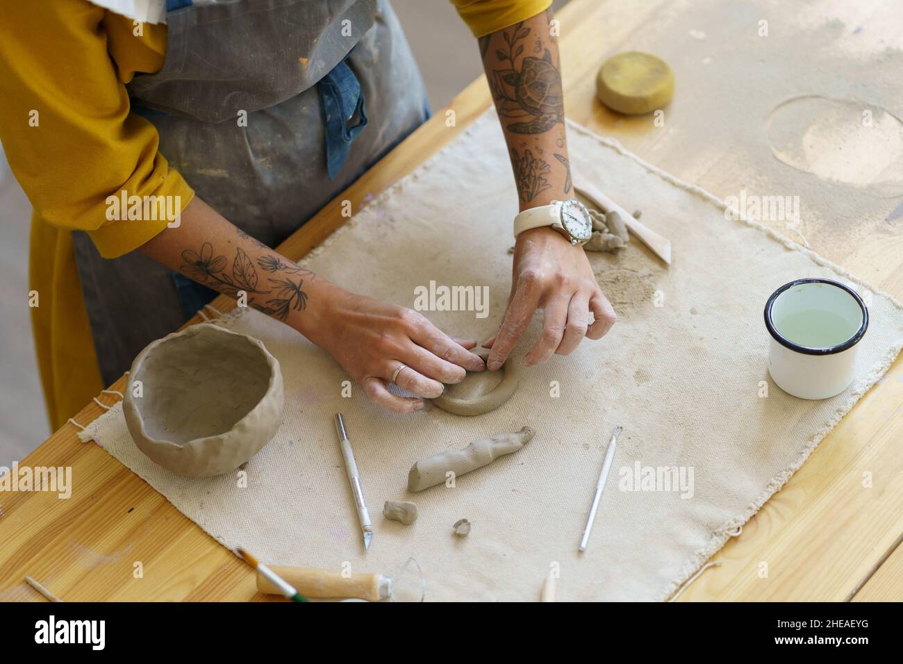 Cropped image of woman learning how to make hand-formed tableware during pottery masterclass Stock Photo