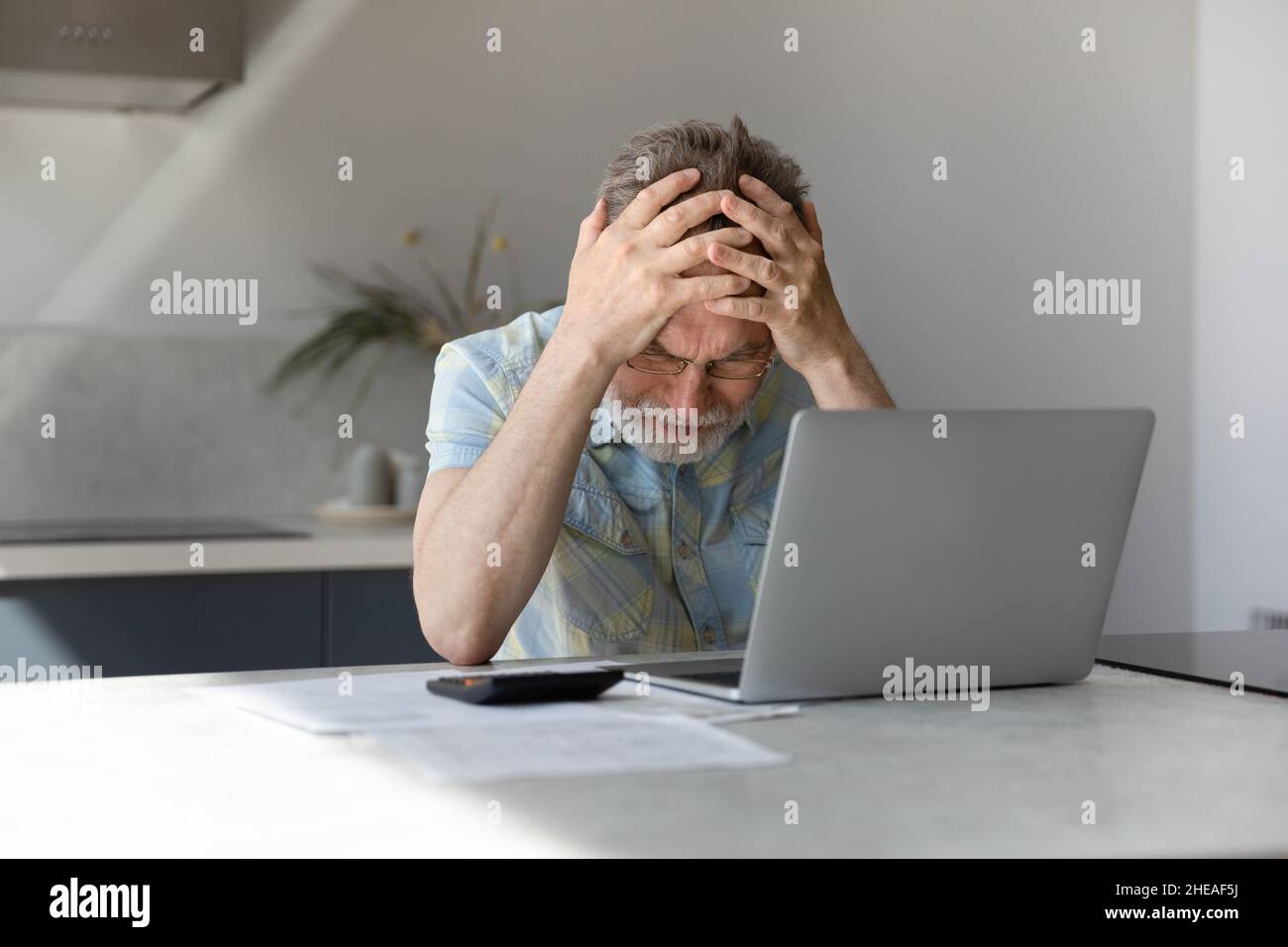 Unhappy frustrated middle aged man having financial problems. Stock Photo