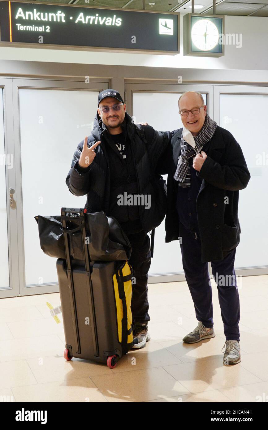 Hamburg, Germany. 09th Jan, 2022. Kirill Serebrennikov (l), film, opera and theater director from Russia, gestures upon his arrival at the airport in Hamburg. Behind him lie more than four years of a strict travel ban and numerous productions via zoom and video throughout Europe. As of today, he is conducting rehearsals for his production of Chekhov's story 'The Black Monk' at the Thalia Theater. Credit: Fabian Hammerl/-/dpa/Alamy Live News Stock Photo