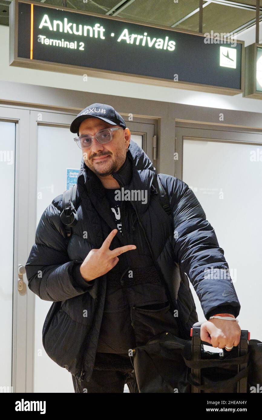 Hamburg, Germany. 09th Jan, 2022. Kirill Serebrennikov, film, opera and theater director from Russia, gestures as he arrives at the airport in Hamburg. Behind him lie more than four years of a strict travel ban and numerous productions via zoom and video throughout Europe. As of today, he is conducting rehearsals for his production of Chekhov's story 'The Black Monk' at the Thalia Theater. Credit: Fabian Hammerl/-/dpa/Alamy Live News Stock Photo