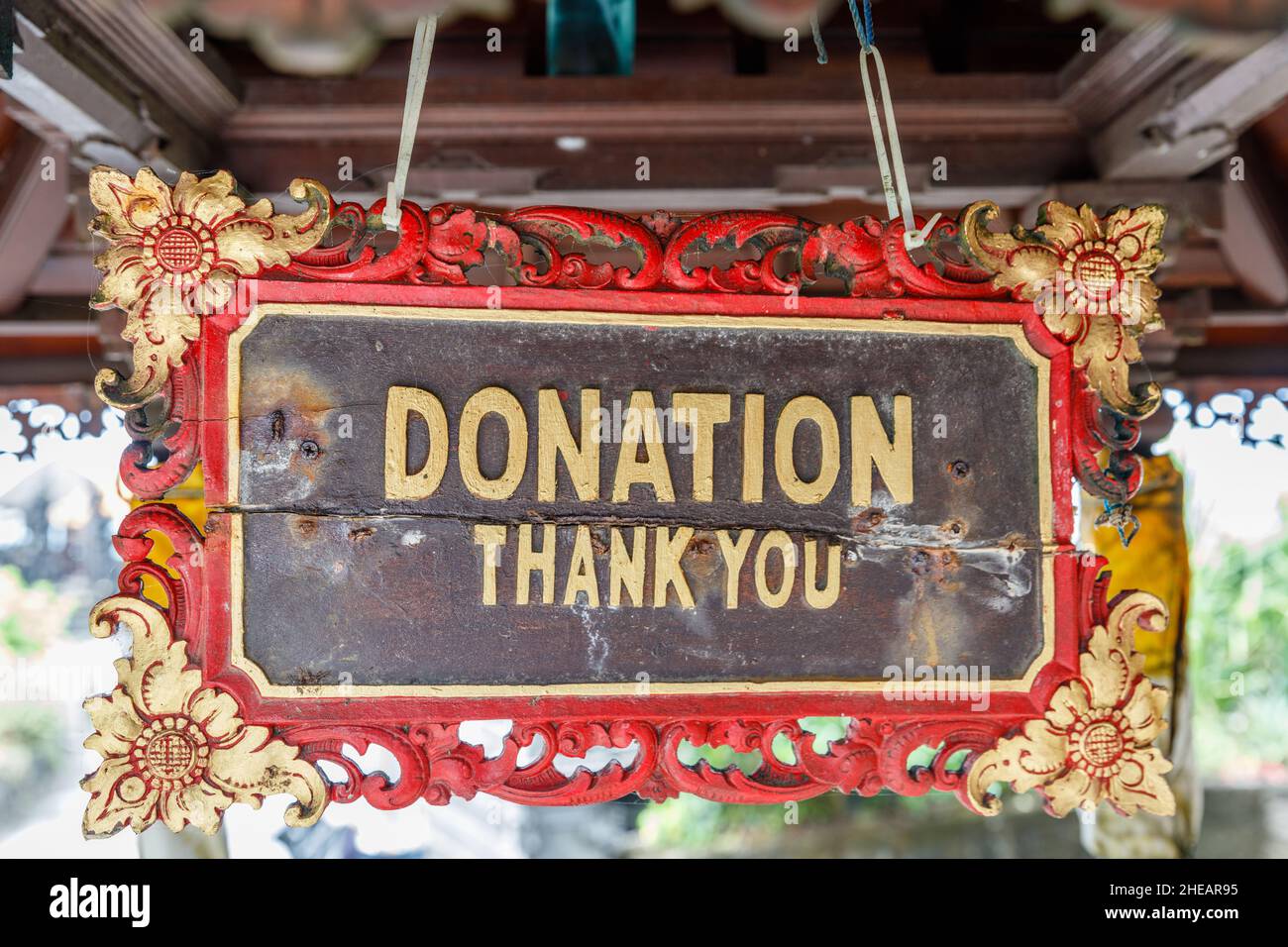 Wooden carved sign "DONATION Thank you" with golden decoration at Hindu