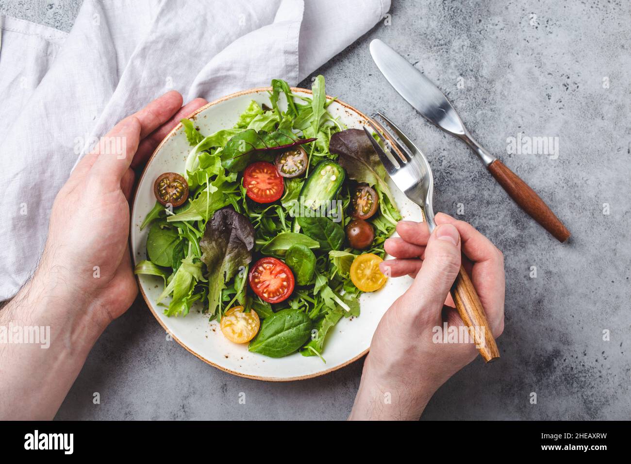 Man eating vegetarian vegetables healthy salad with red and yellow cherry tomatoes Stock Photo