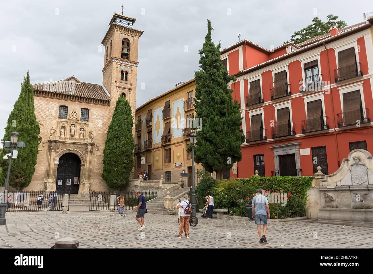 Granada Spain - 09 14 2021: View at the St. Ana square with San Gil and Santa Ana Church, heritage colored buildings and Carrera del Darro to the stre Stock Photo