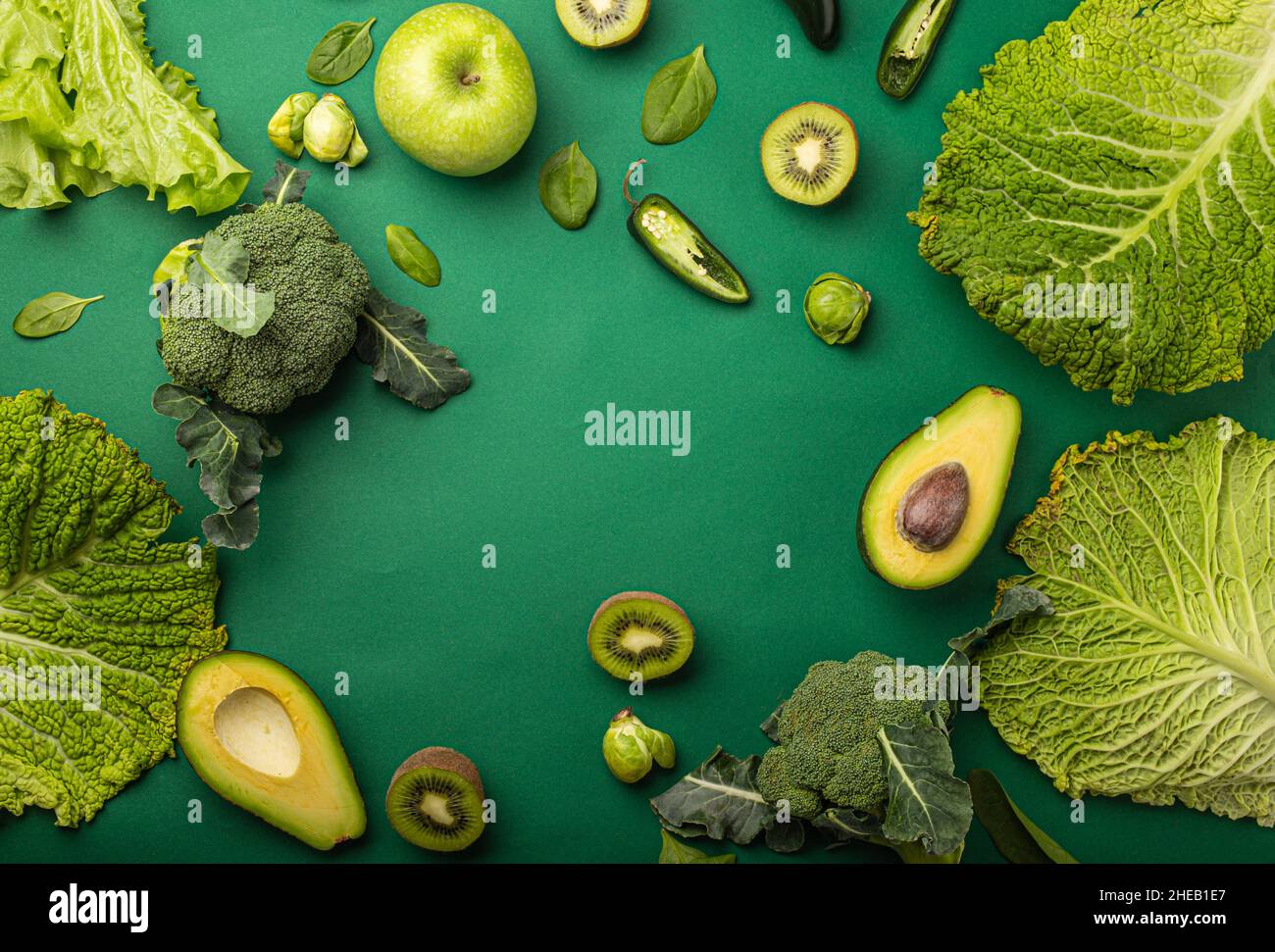 Creative layout food concept made of green fruit and vegetables on green background Stock Photo