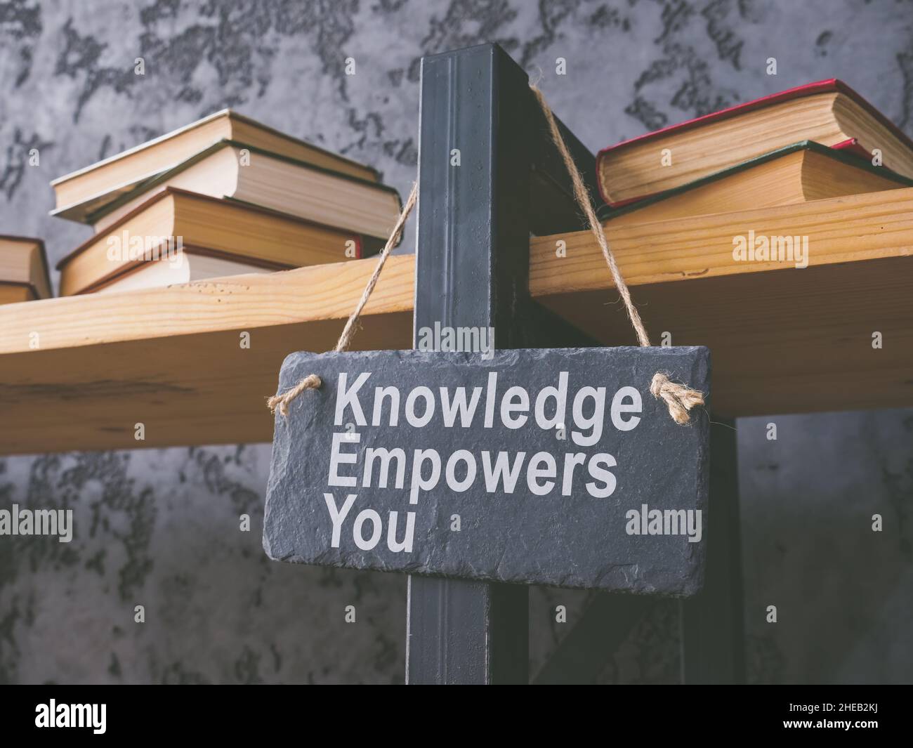 Book shelf and plate knowledge empowers you. Stock Photo