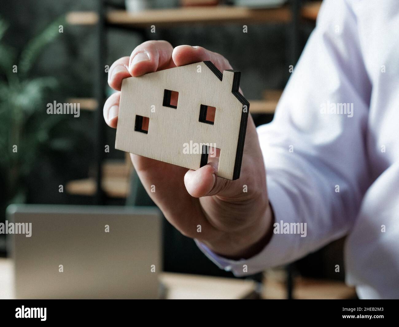 Mortgage or buying house concept. Manager shows model of home. Stock Photo