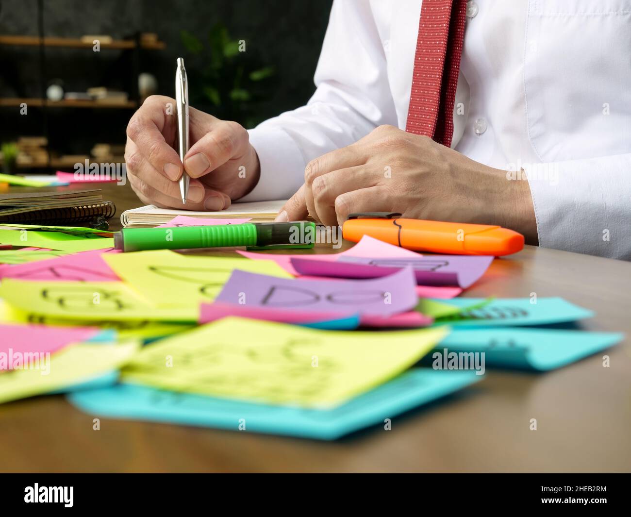 The manager works with papers at the table. Lots of multicolored stickers. Stock Photo