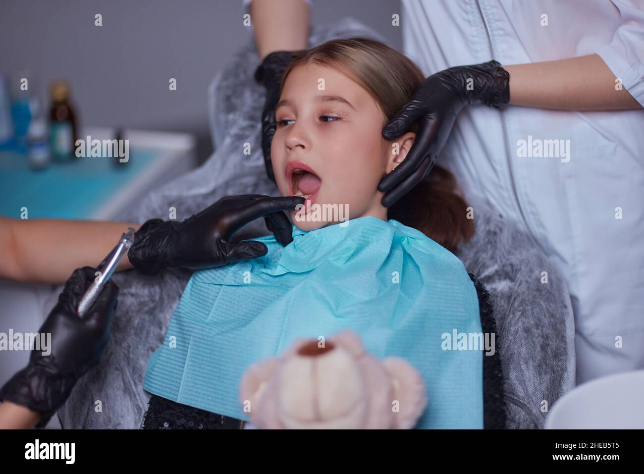 Dentist use anesthetic injection for tooth extraction in child Stock