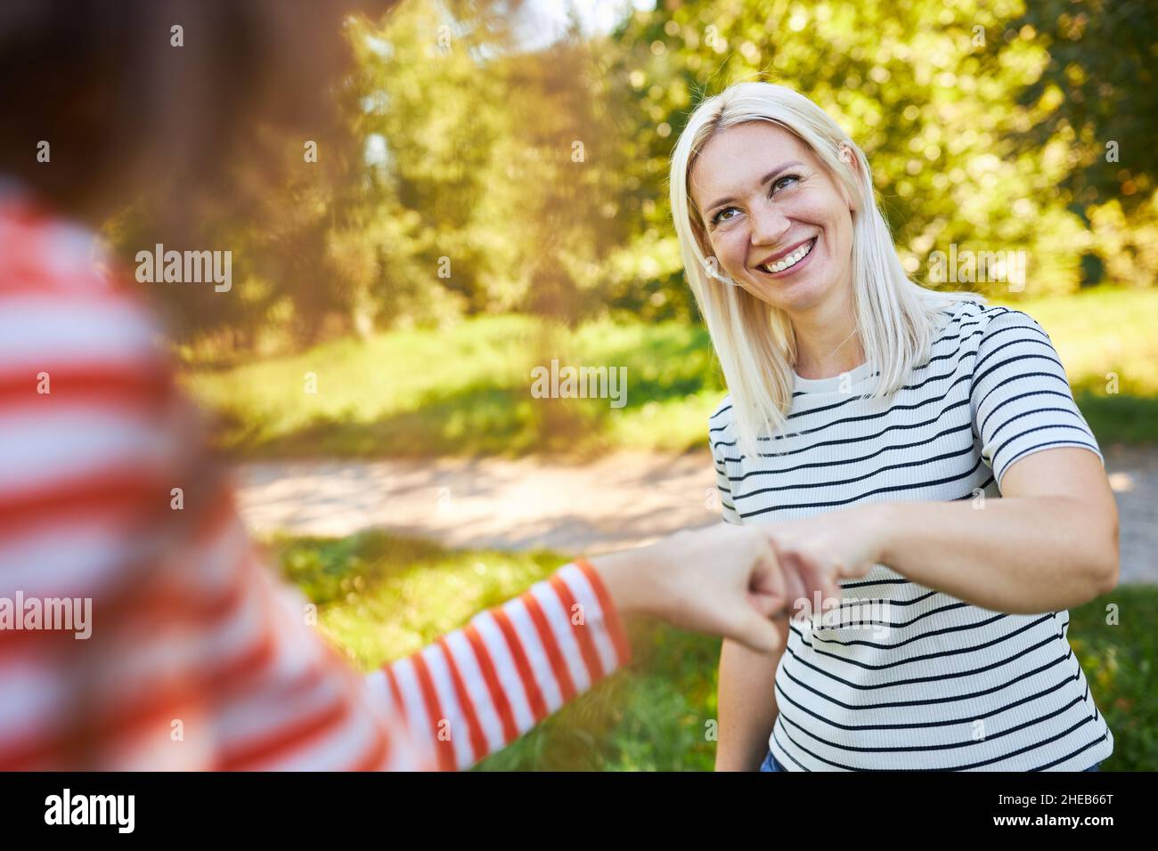 Two young women as friends during a fist bump as a symbol for teamwork and motivation Stock Photo