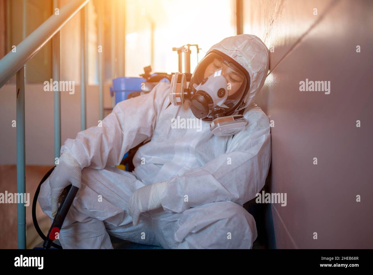 Tired, health workers wear PPE, spraying disinfectants to prevent the spread of germs or coronavirus. Stock Photo