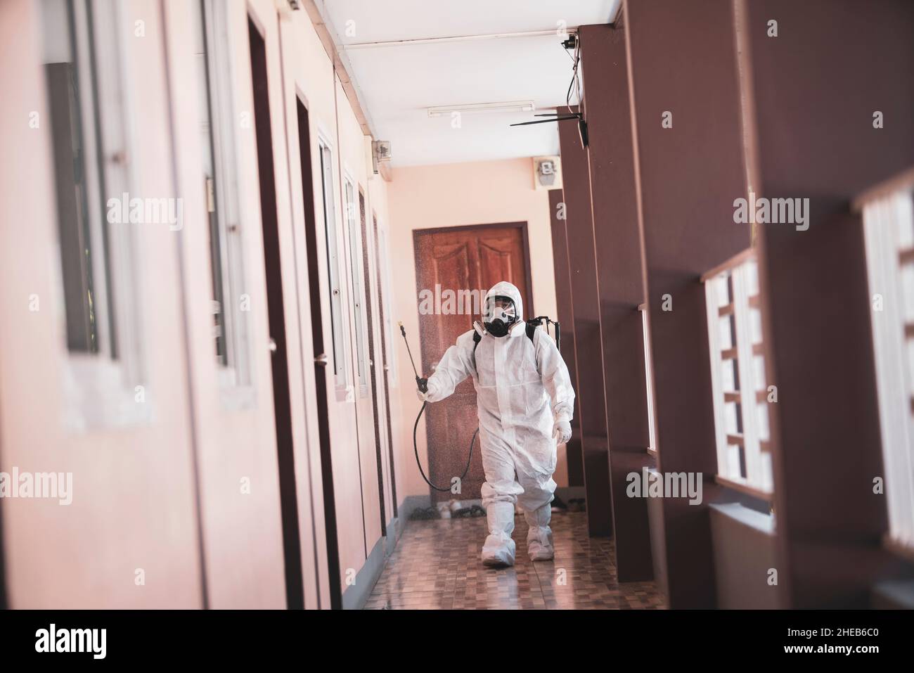 Epidemiologists or health workers wear PPE, spraying disinfectants to prevent the spread of germs or coronavirus. Stock Photo