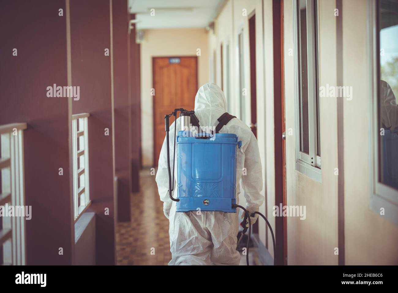 Behind medical staff wearing PPE uniform spraying disinfectant against the spread of the virus. Stock Photo