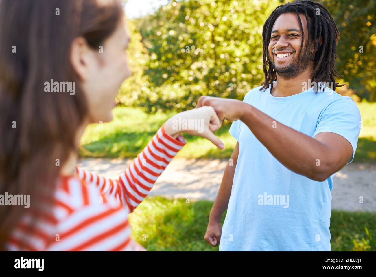 Young African man makes fist bump with girlfriend as a greeting and motivation Stock Photo