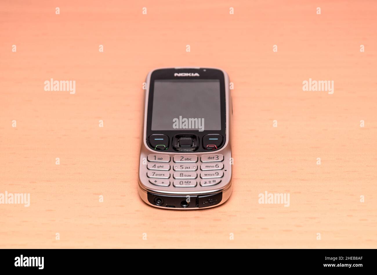 Nokia 6303 classic mobile phone from 2009 on wooden background Stock Photo