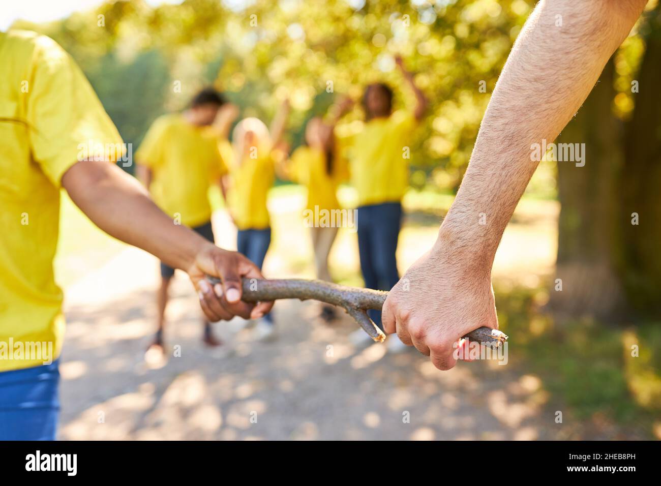 Young people in the relay race hand over the baton in the team building workshop Stock Photo