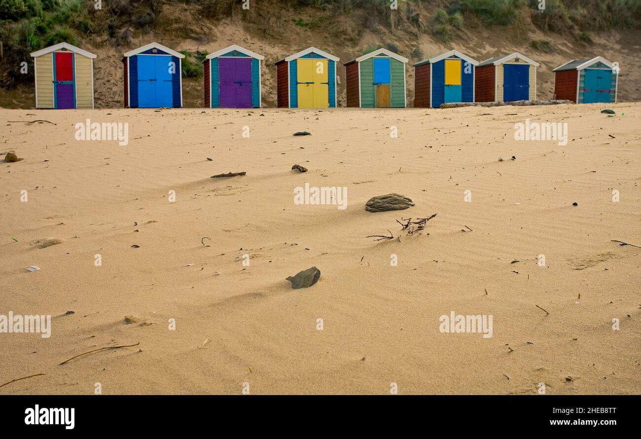 Colourful beach huts at Saunton sands Devon with no persons in shot with copy space with sand foreground. Stock Photo