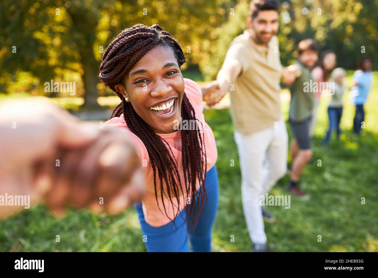 African woman and friends holding hands in team building workshop Stock ...