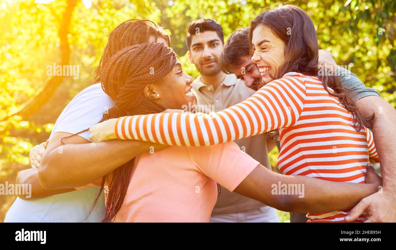 Multicultural friends embrace as a community as a sign of solidarity and togetherness Stock Photo
