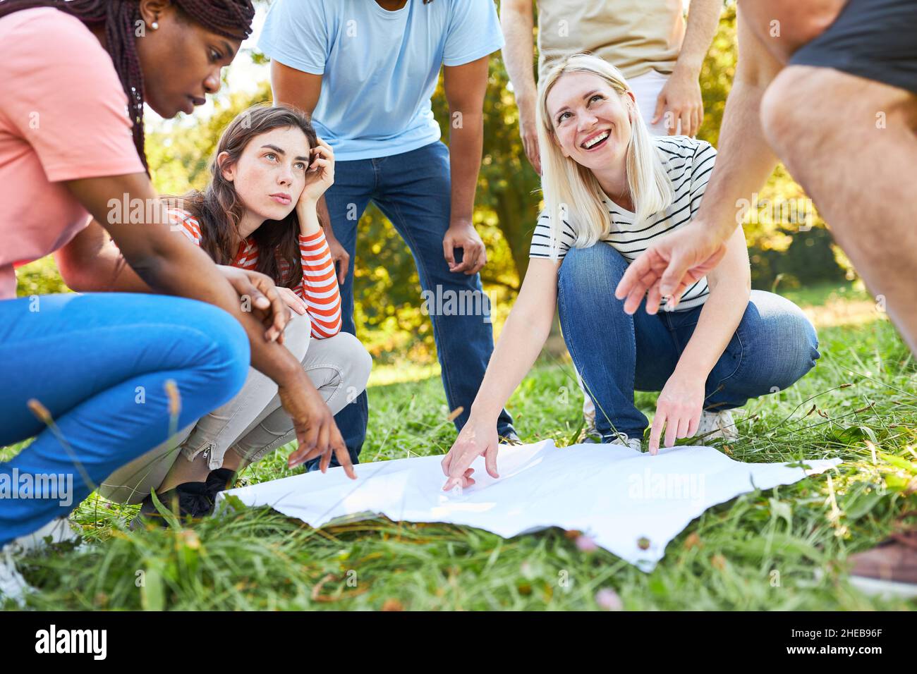 Group of friends with a map on the treasure hunt for cooperation and ...