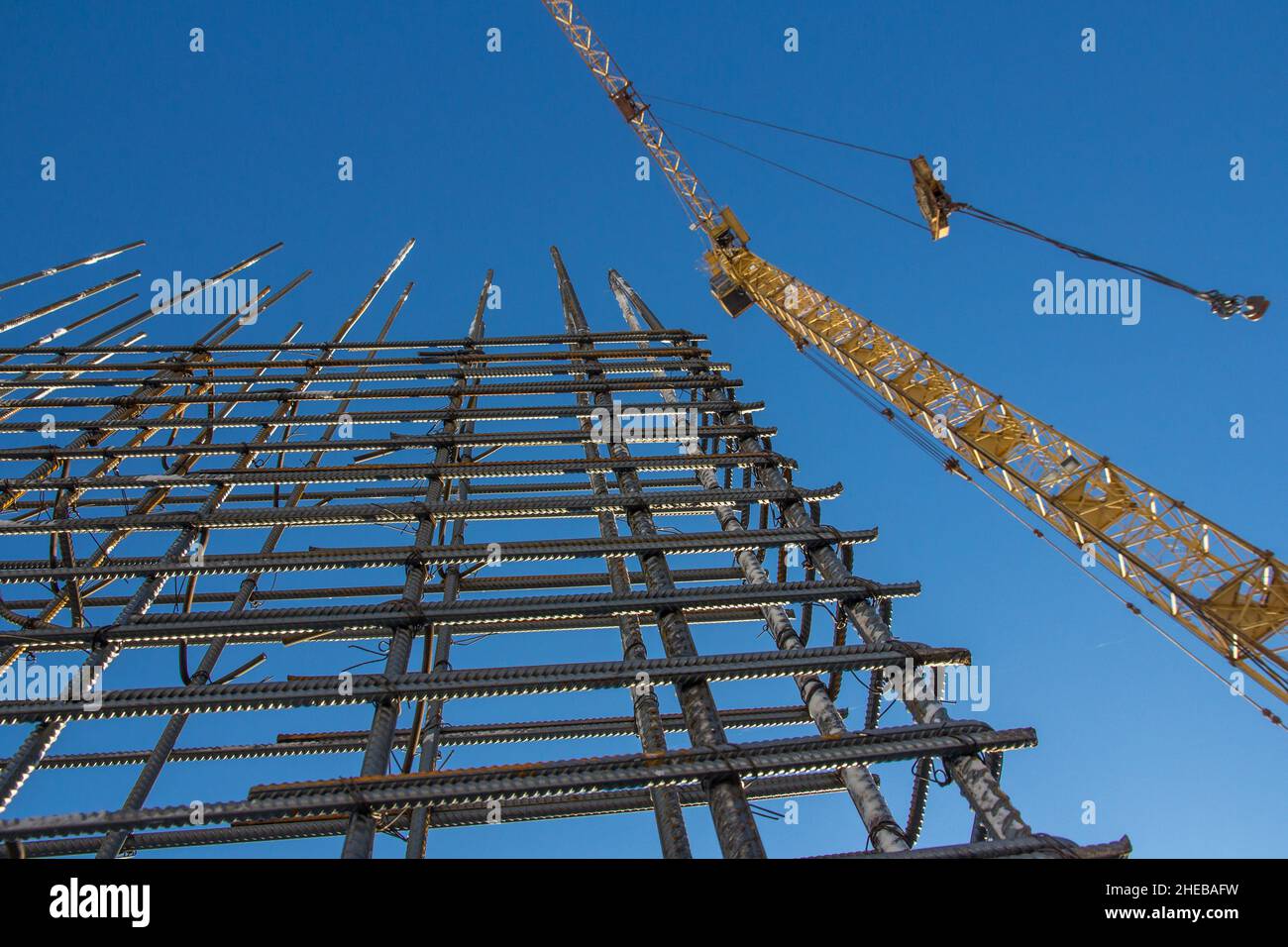A reinforced steel rebar foundation work and tower crane against the