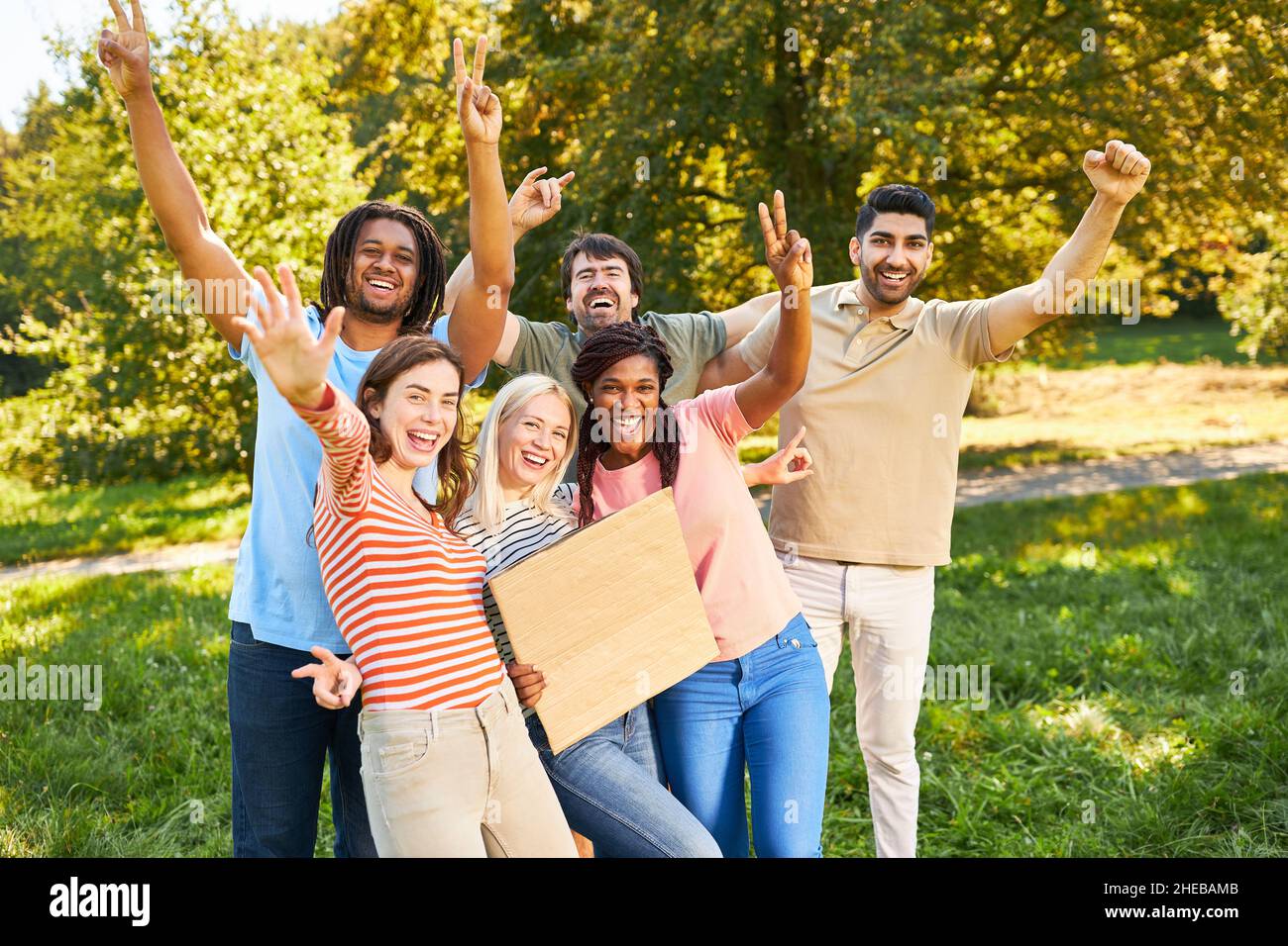 Young people as a successful start-up team cheer together on a meadow in summer Stock Photo