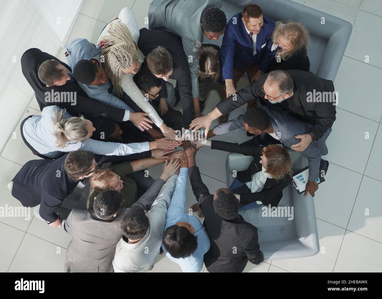 Diverse business people group put hands together in stack pile at training as concept of sales team corporate unity connection Stock Photo