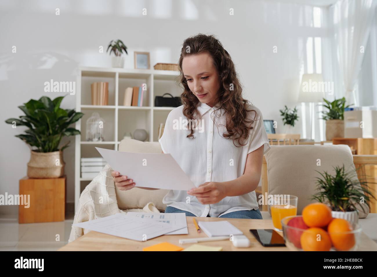 Smiling young manager checking documents with application interface layout made by UI designer Stock Photo