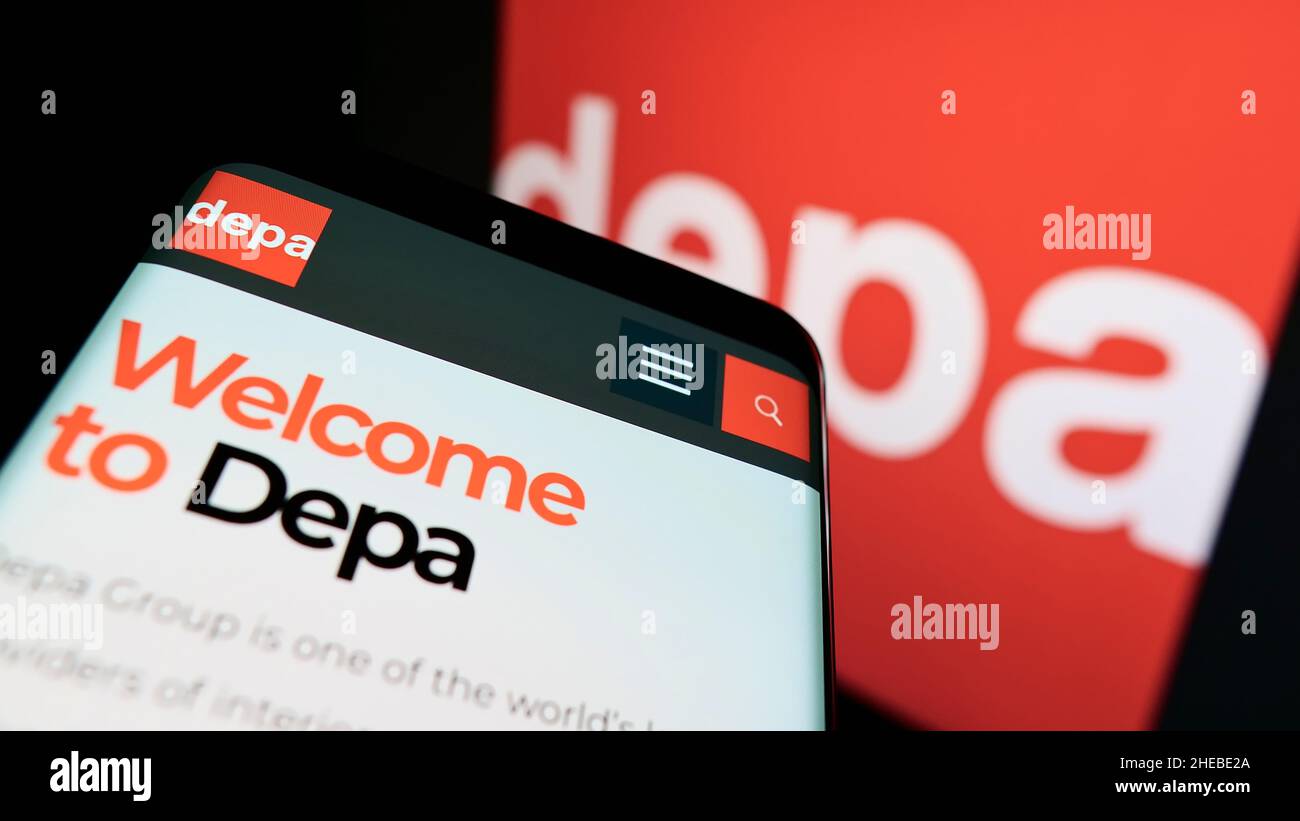 Smartphone with webpage of interior construction company Depa Plc on screen in front of business logo. Focus on top-left of phone display. Stock Photo