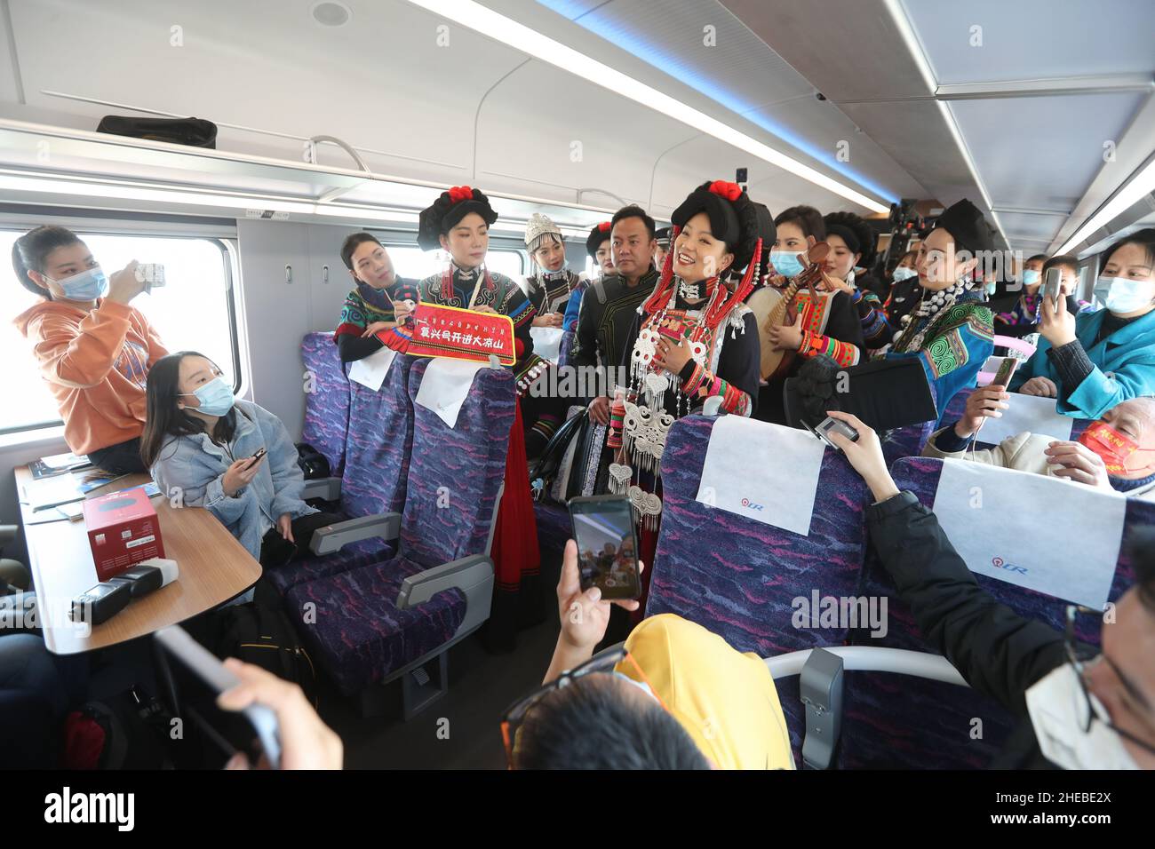 (220110) -- CHENGDU, Jan. 10, 2022 (Xinhua) -- A singer of Yi ethnic group performs on D843 'Fuxing' bullet train, in Liangshan Yi Autonomous Prefecture, southwest China's Sichuan Province, Jan. 10, 2022.  A 'Fuxing' high-speed Electric Multiple Unit (EMU) left Xichang City in Liangshan Yi Autonomous Prefecture, southwest China's Sichuan Province, for Kunming, capital of southwest China's Yunnan Province, on Monday.   It marked the departure of the first 'Fuxing' bullet train from the prefecture in the remote Daliang Mountain, one of China's most recent areas to shake off abject poverty.   The Stock Photo