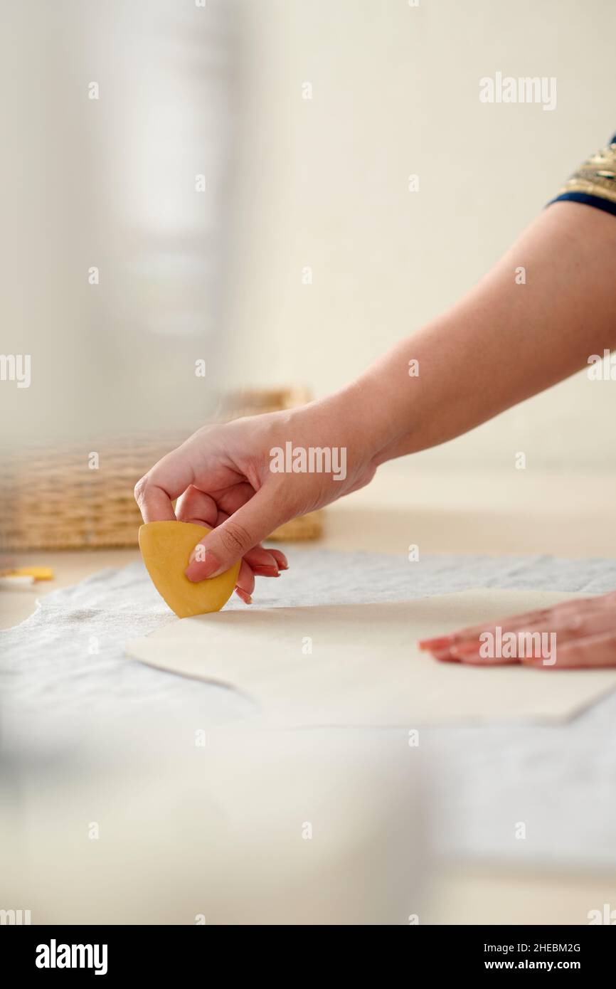 Hands of seamstress using chalk when marking out sewing pattern on