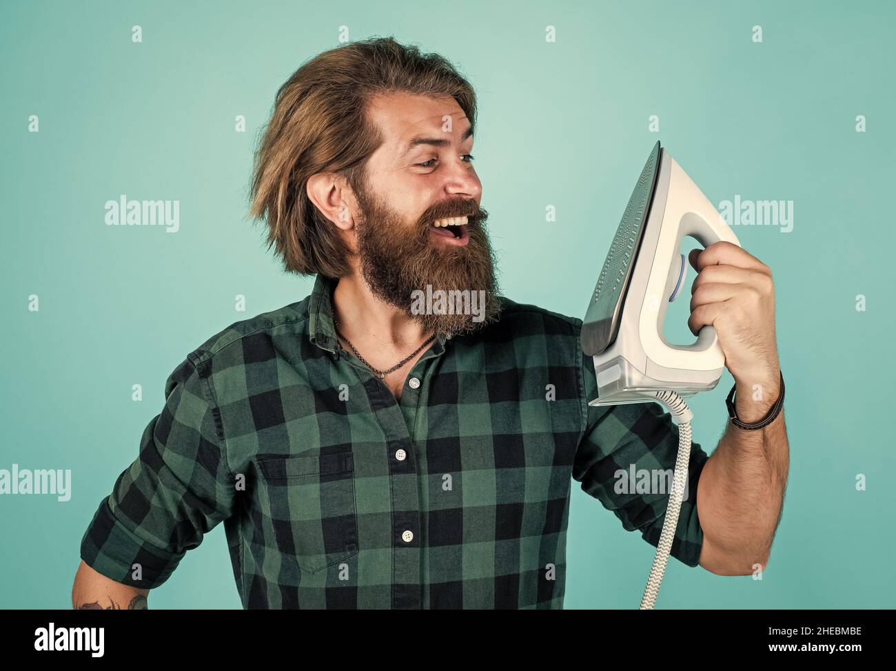 mature man with beard and trendy hairstyle use steaming iron, household  Stock Photo - Alamy
