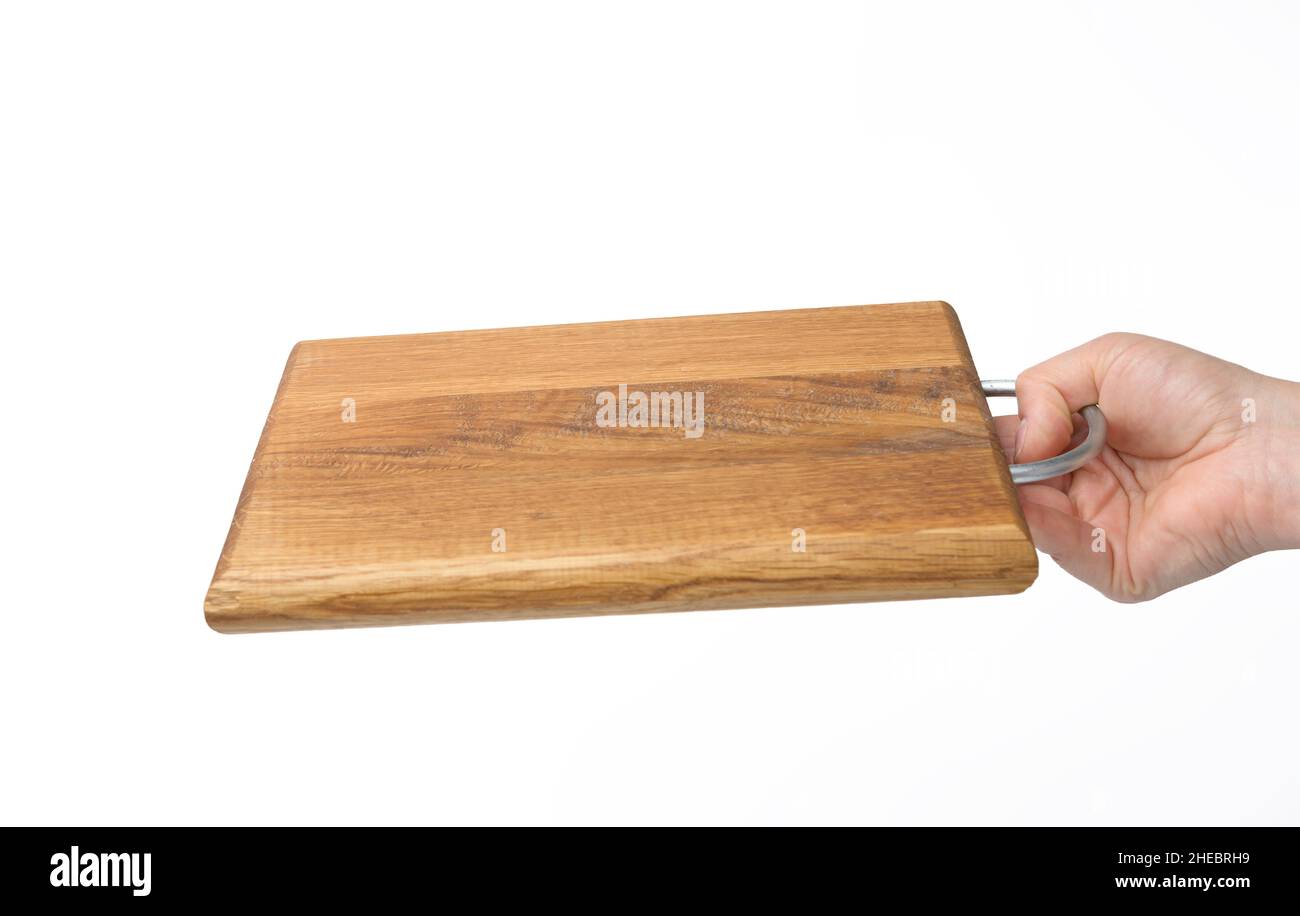 female hands hold empty rectangular brown wooden chopping board on white background Stock Photo