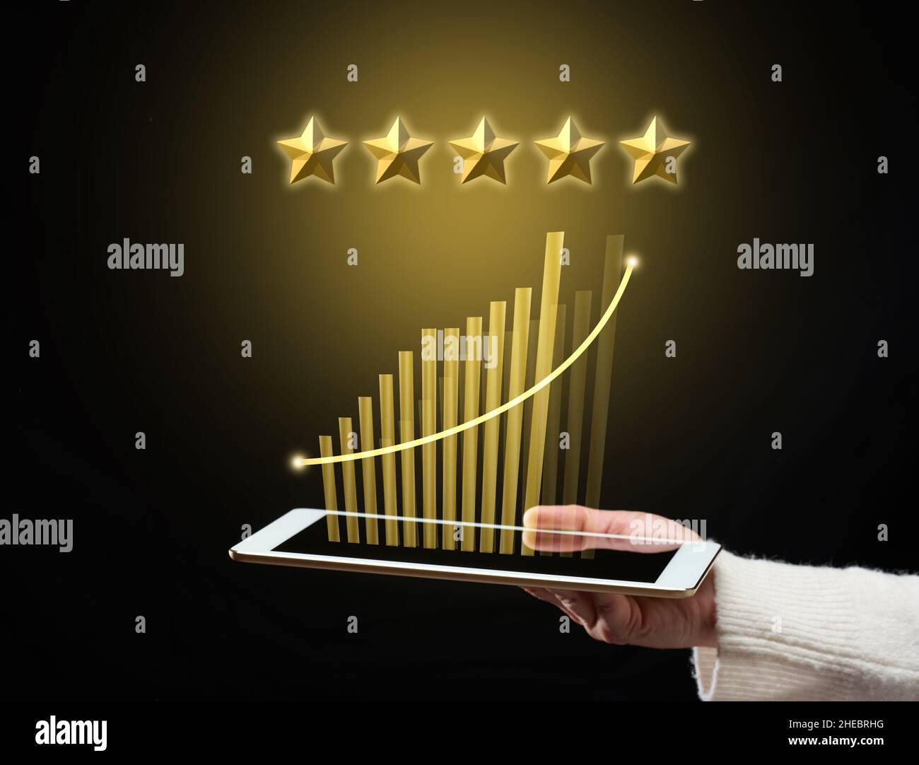 female hand holds a tablet and five gold stars above it. App evaluation. User reviews, business rating Stock Photo