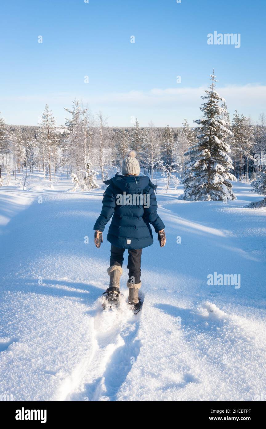 Kid walking with snow shoes in fresh snow, Kuusamo, Finland Stock Photo