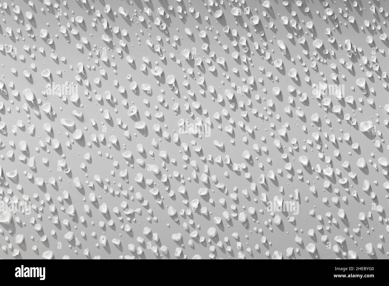 Water droplets on a white background with shadows from the light shining down on them,Abstract background image in the concept of art. Stock Photo