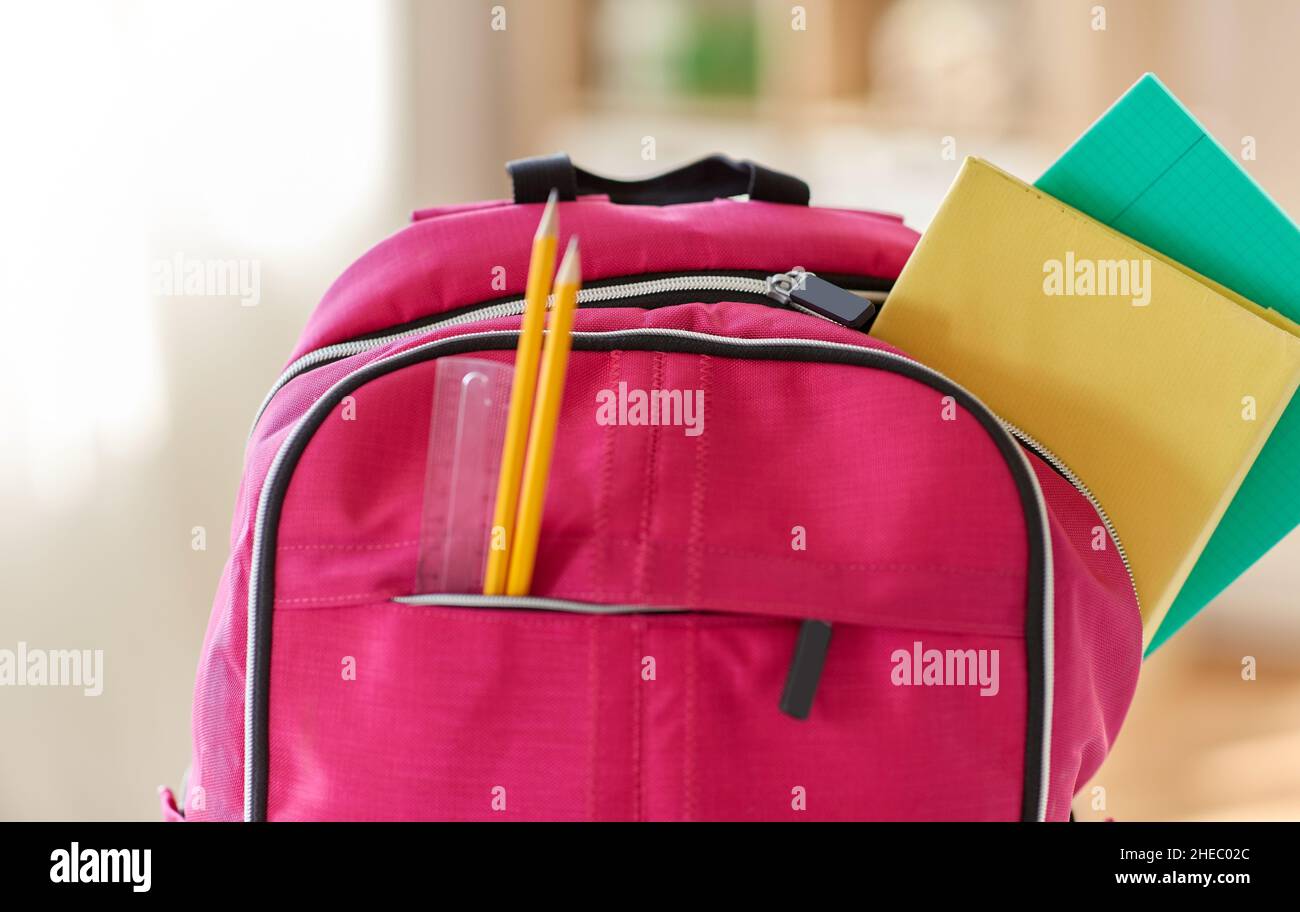 pink backpack with books and school supplies Stock Photo