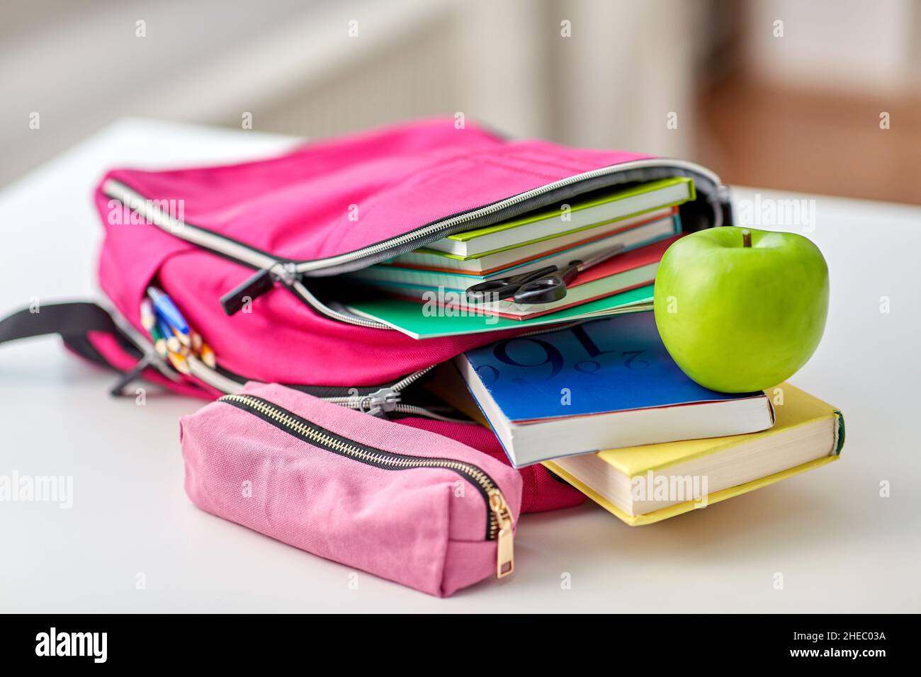 backpack, apple and school supplies on table Stock Photo