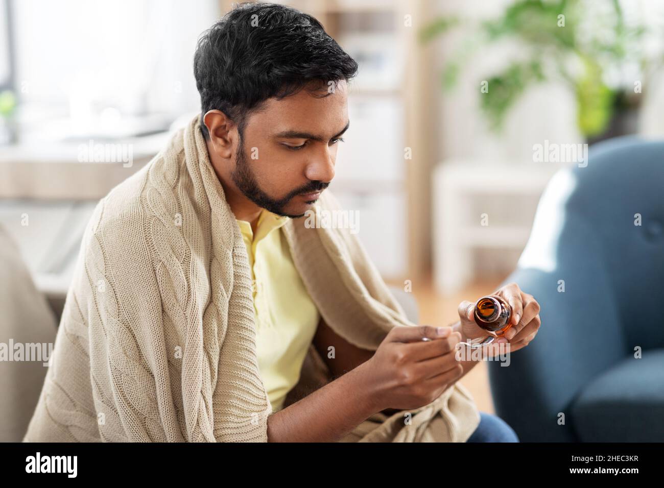sick man pouring medication from bottle to spoon Stock Photo