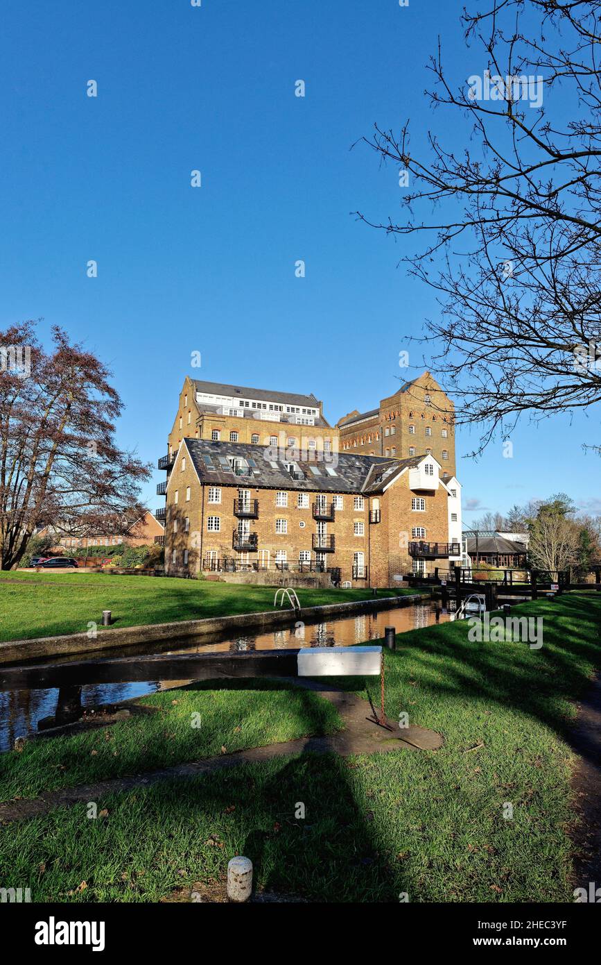 Coxes Lock Mill apartments on the River Wey Navigation canal on a sunny